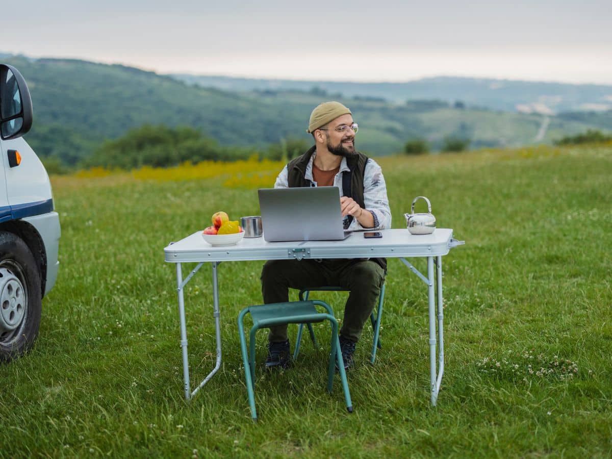 Remote work setup outdoors with laptop at campsite, showing importance of internet when camping while working.