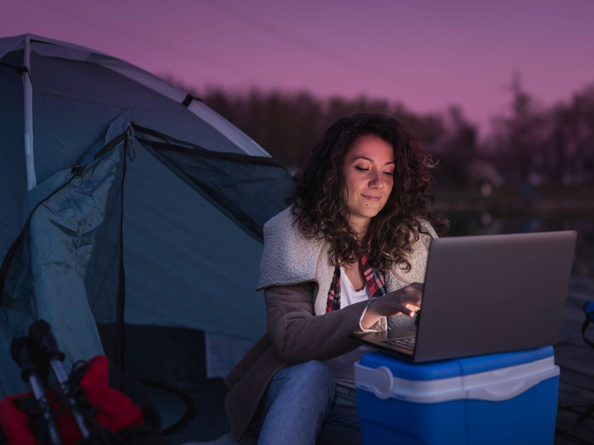 Camping at night with laptop setup, illustrating power and battery challenges when working while camping.