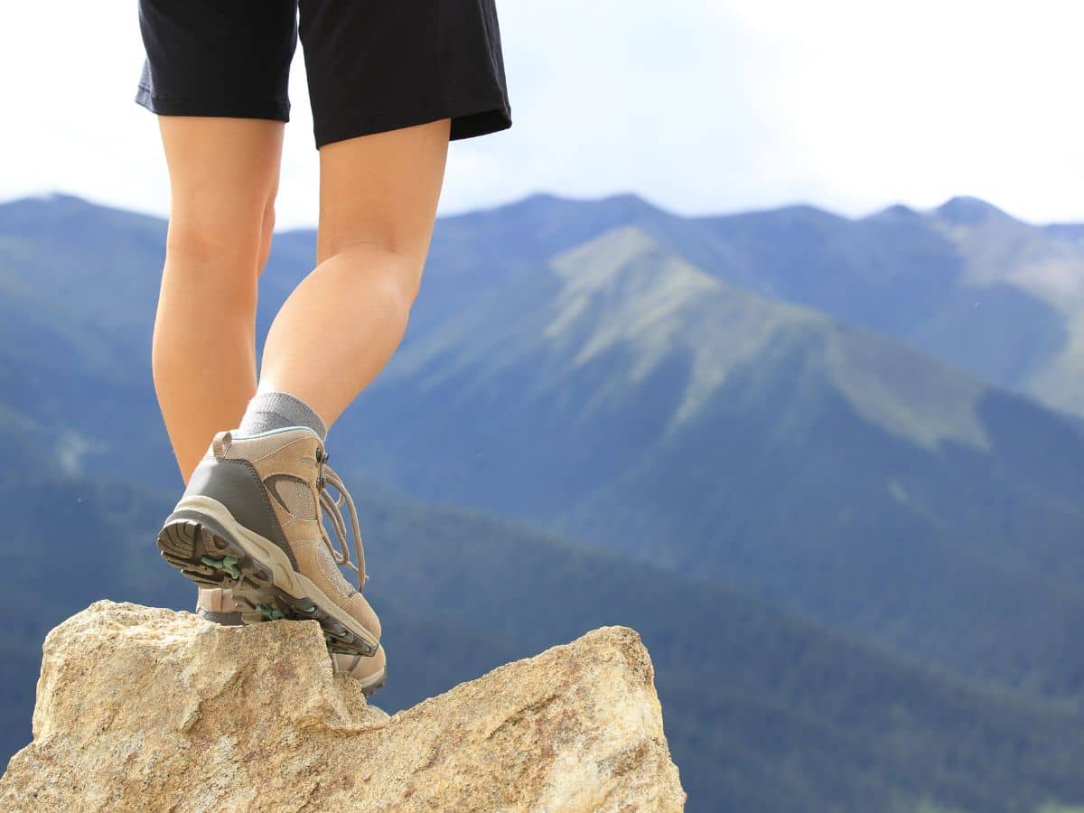 Close-up of hiking shoes and socks on a sunny trail where feet can get hot and sweaty.