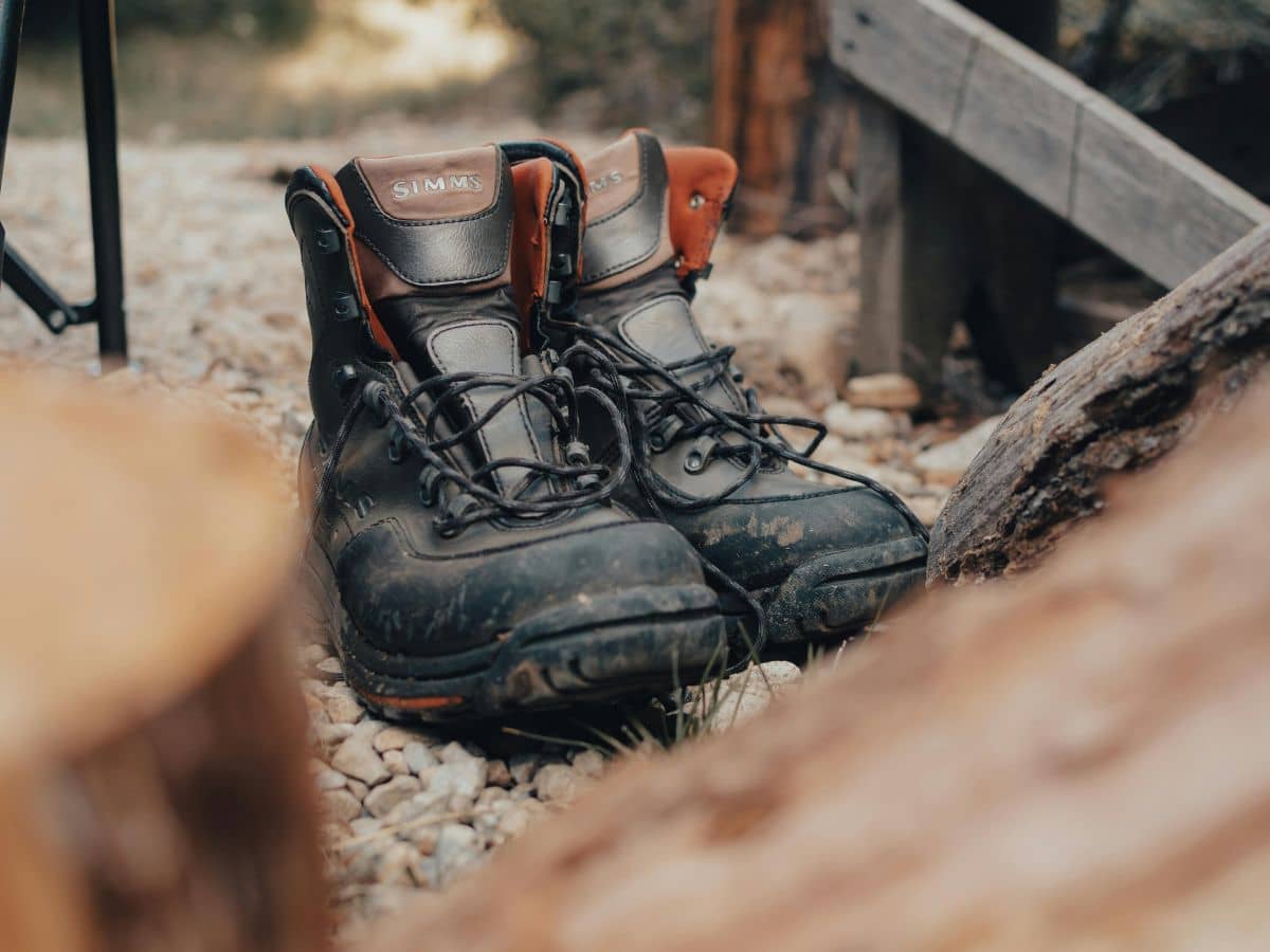 Scuffed hiking boots on a rocky woodland trail, showing how to break in hiking boots by gradually introducing rougher terrain.
